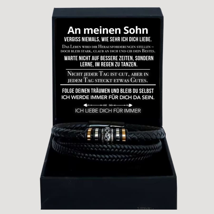 Geöffnete Box mit schwarzer Botschaftskarte in weißer Schrift, Armband liegt auf dunklem Boxeinsatz