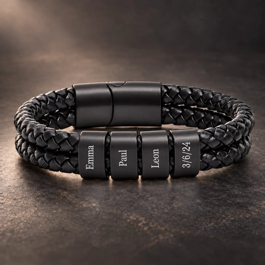 Schwarzes geflochtenes Lederarmband mit vier gravierten Beads Emma, Paul, Leon und 3/6/24 auf dunklem Untergrund