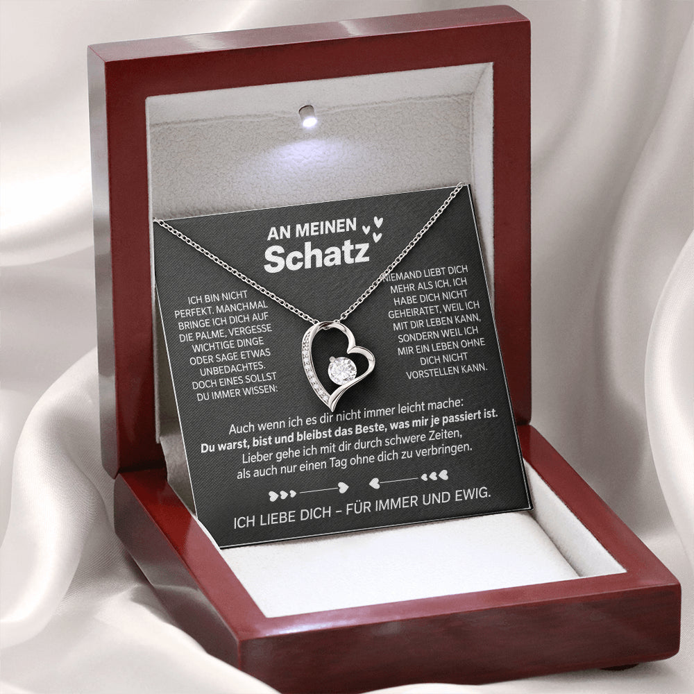 Weißgold-Herzanhänger auf der Karte An meinen Schatz in der geöffneten Mahagoni-Box mit LED-Licht, auf weißem Satin