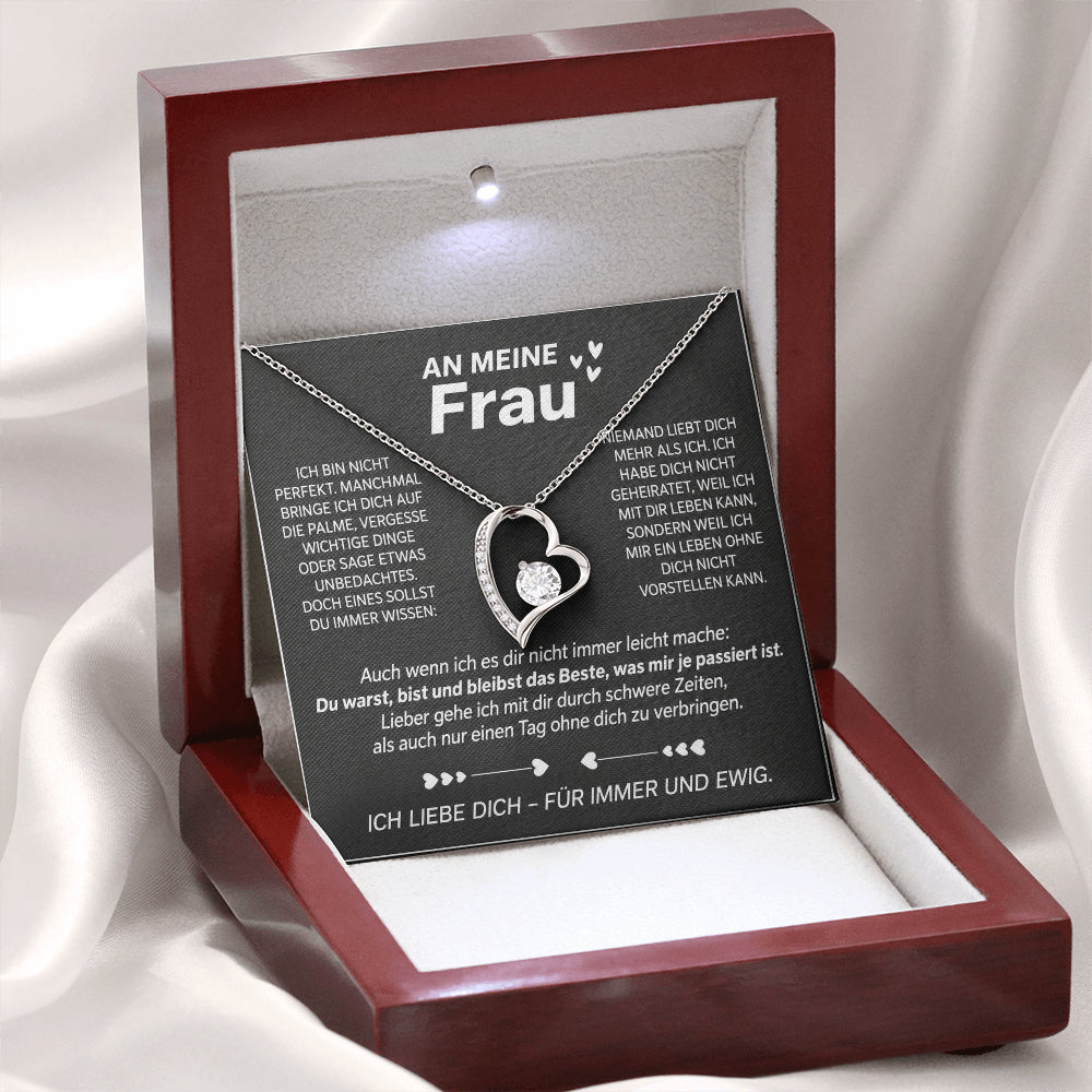 Weißgold-Herzanhänger auf der Karte An meine Frau in der geöffneten Mahagoni-Box mit LED-Licht, auf weißem Satin