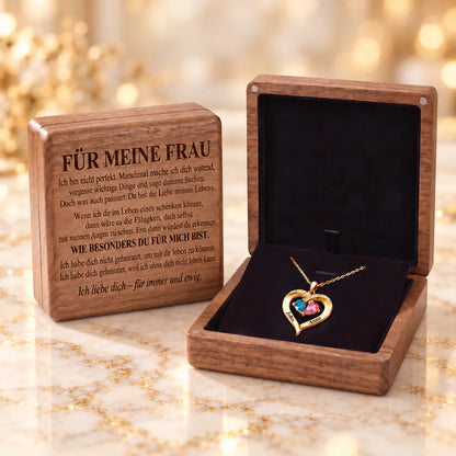 Gelbgold-Geburtsstein-Herzanhänger mit Namen John und Anna in der geöffneten Walnussbox, daneben eine Box mit der Gravur Für meine Frau