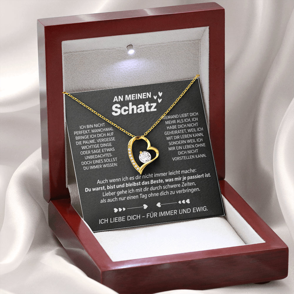 Gelbgold-Herzanhänger auf der Karte An meinen Schatz in der geöffneten Mahagoni-Box mit LED-Licht, auf weißem Satin