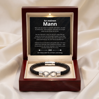 Braune Holzgeschenkbox auf weißem Seidenstoff, geöffnet mit Botschaftskarte und Armband mit silbernem Infinity-Anhänger