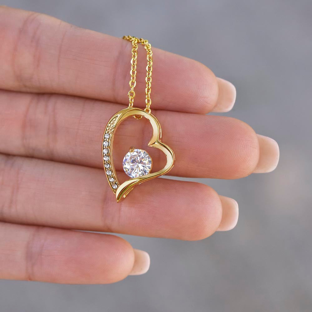 Goldener Herzanhänger mit Zirkonia in der Hand, Nahaufnahme