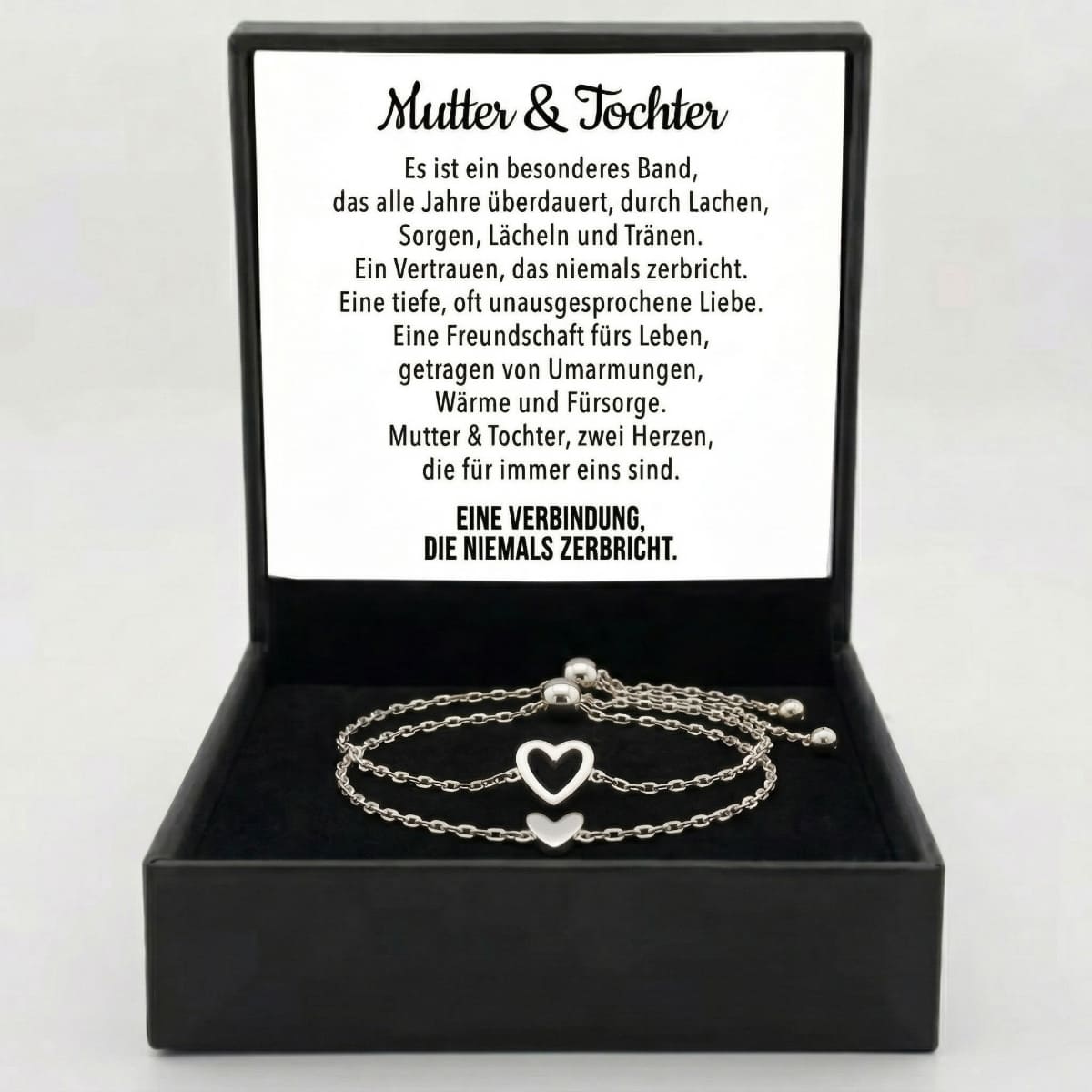 Zwei silberne Herz-Armbänder liegen in einer offenen Geschenkbox neben der Gedichtkarte für Mutter und Tochter.