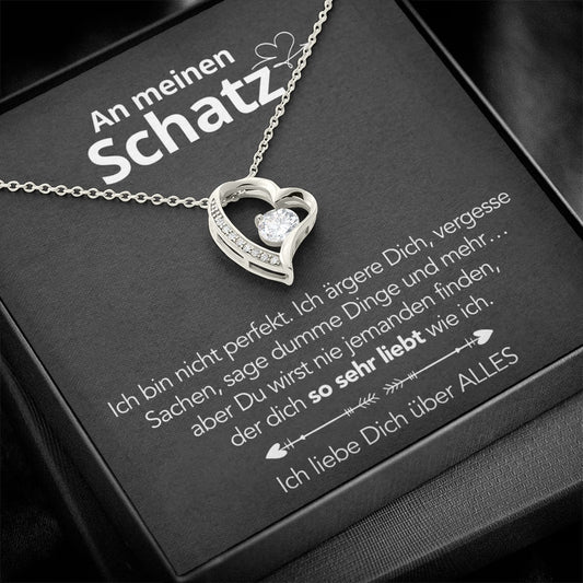 Offener Herzanhänger in Weißgold mit Stein auf der Geschenkkarte An meinen Schatz, flach auf schwarzem Untergrund.