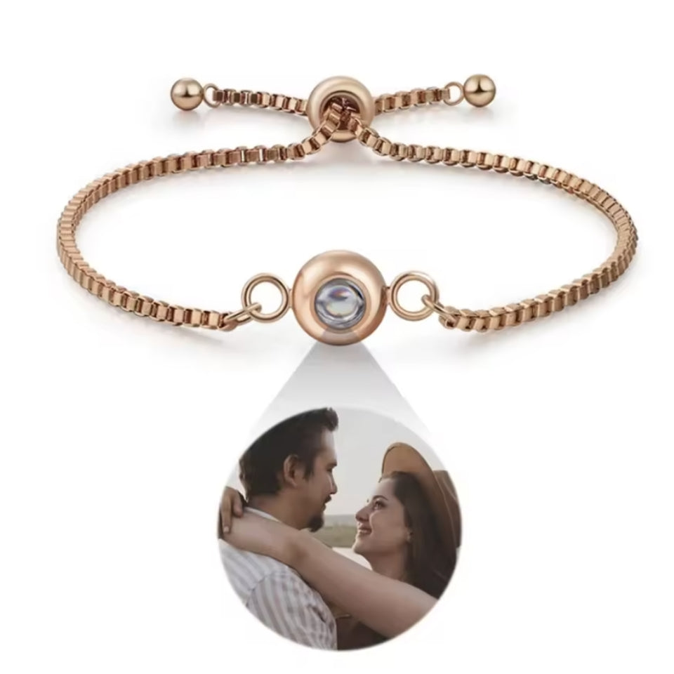Fotoarmband in Roségold mit rundem Anhänger vor weißem Hintergrund, Pärchenfoto tropfenförmig darunter