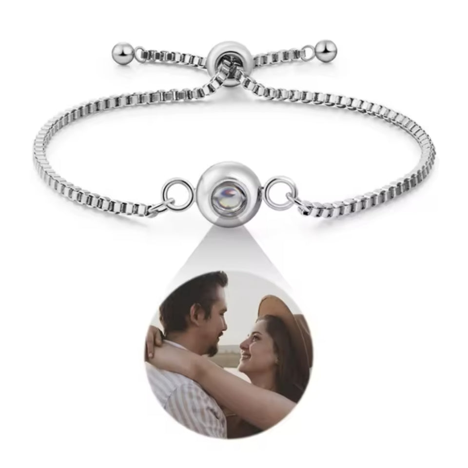 Weißgold-Fotoarmband mit rundem Anhänger vor weißem Hintergrund, Pärchenfoto tropfenförmig darunter