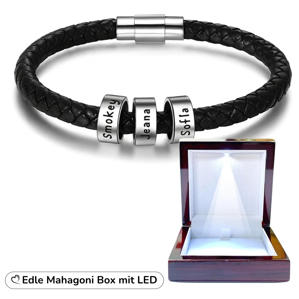 Schwarzes Lederarmband mit drei gravierten Beads neben geöffneter Mahagoni-Box mit LED-Beleuchtung