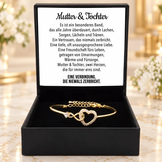 Goldfarbenes Armband mit offenem Zirkonia-Herz in schwarzer Geschenkbox, Deckelkarte mit Mutter-Tochter-Gedicht.