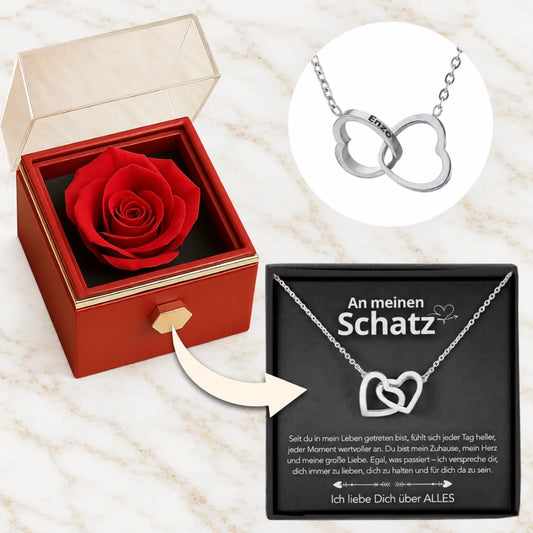 Geöffnete rote Rosenbox mit Rose, Doppelherz-Halskette in 14k Weißgold und Karte An meinen Schatz auf hellem Marmor