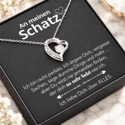 Weißgold-Herzanhänger auf Karte An meinen Schatz in schwarzer Premium-Box, schräge Nahaufnahme auf hellem Marmor