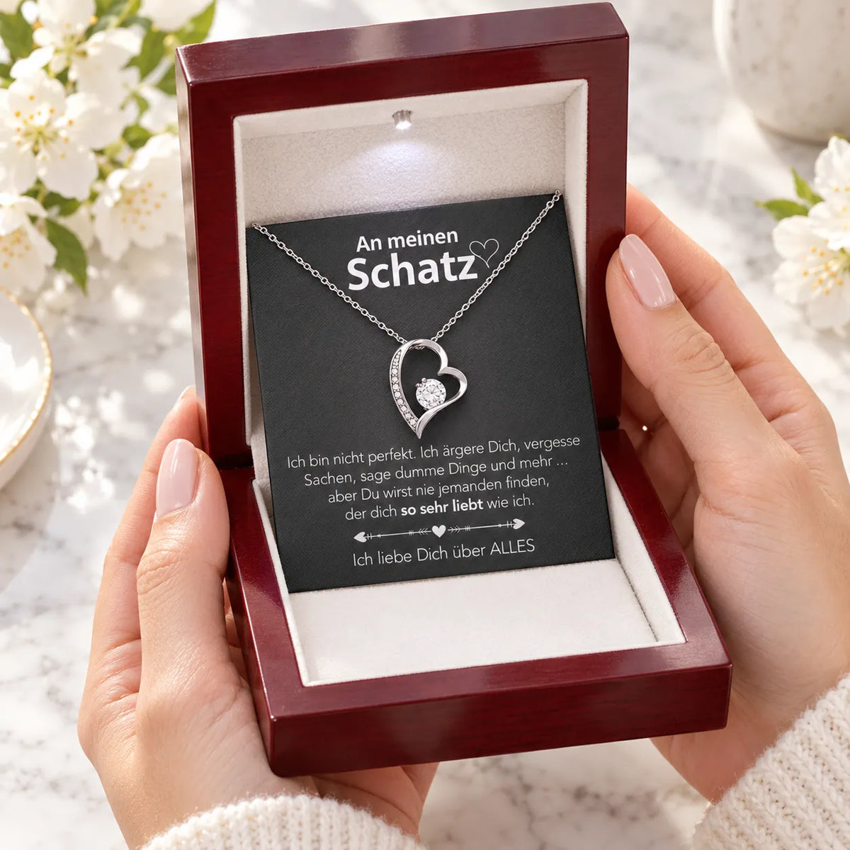 Weißgold-Herzanhänger mit Karte An meinen Schatz in Mahagoni-Box als Geschenk in den Händen