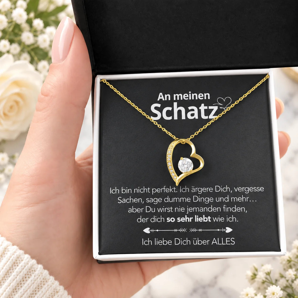 Gelbgold-Herzanhänger mit Karte An meinen Schatz in schwarzer Geschenkbox, Detail in der Hand