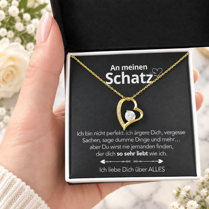 Gelbgold-Herzanhänger mit Karte An meinen Schatz in schwarzer Geschenkbox, Detail in der Hand
