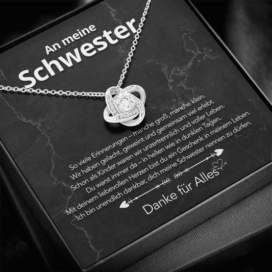 Weißgold-Liebesknoten-Anhänger auf schwarzer Karte An meine Schwester, schräg in schwarzer Box, Text Danke für Alles